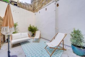 zwei Stühle und ein Regenschirm auf einer Terrasse in der Unterkunft Beautiful apartment in Chartrons with terrace in Bordeaux