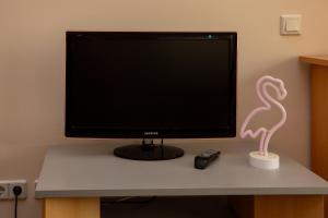 a computer monitor with a pink flamingo on a desk at Ferienwohnung Hirschgrundblick in Oberlungwitz