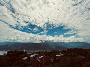 a cloudy sky with a view of a mountain at Sarangkot Toripani Homestay in Pokhara
