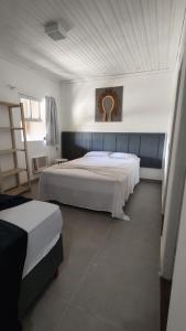 a bedroom with two beds and a clock on the wall at Pousada Coração do Rosa in Praia do Rosa