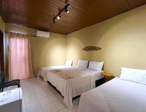 um quarto de hotel com duas camas e uma janela em VILA LITORANEA a em São Luís