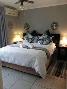 a bedroom with a large white bed with two lamps at St Lucia Ocean View Lodge in St Lucia