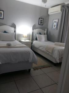 sypialnia z 2 łóżkami i stołem z lampką w obiekcie St Lucia Ocean View Lodge w mieście St Lucia