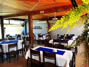 restauracja ze stołami i krzesłami z niebieskimi serwetkami w obiekcie Hotel Amatista w mieście Wanda