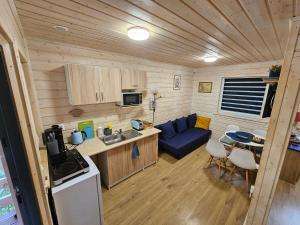 a kitchen and living room in a tiny house at Czerwone Domki Wartowo in Kołczewo