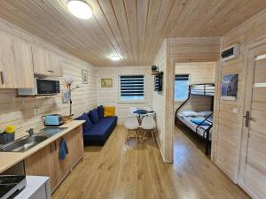 a kitchen and living room in a tiny house at Czerwone Domki Wartowo in Kołczewo