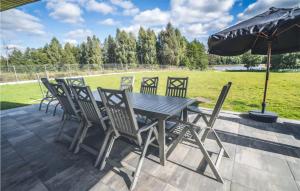 a wooden table with chairs and an umbrella on a patio at Beautiful Home In Ryn With House A Panoramic View in Ryn