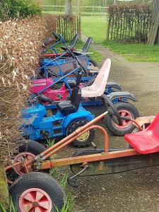 a row of four toy vehicles parked in a yard at Camping de Peelweide in Grashoek