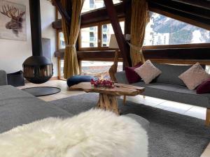 een woonkamer met een bank en een tafel bij 90m2 hypercentre, terrace, next to ski lift in Chamonix-Mont-Blanc