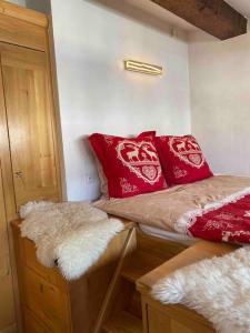 Cette petite chambre comprend 2 lits avec des oreillers rouges. dans l'établissement 90m2 hypercentre, terrace, next to ski lift, à Chamonix-Mont-Blanc