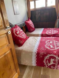 a bedroom with two beds with red and white sheets at 90m2 hypercentre, terrace, next to ski lift in Chamonix-Mont-Blanc