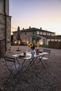 stół i krzesła z wazonem kwiatów w obiekcie Villa l'Essiccatoio Deluxe Morcella w mieście Morcella