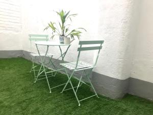 two chairs and a table with a potted plant at Victoria Belgravia Townhouse Apartments in London