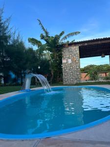 uma piscina com uma fonte de água num quintal em Casa 2 Gold Star Village em Majorlândia