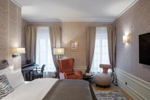 um quarto de hotel com uma cama e uma cadeira em Hotel Unicus Palace Old Town em Cracóvia