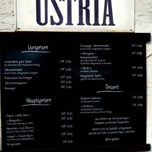 a sign for a menu for a restaurant at Ustria Crusch Alva in Tavanasa