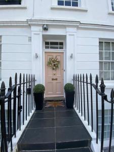 a front door of a house with a wreath on it at Victoria Belgravia Townhouse Apartments in London