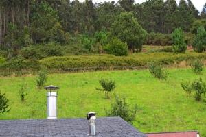 a roof of a house with a field in the background at Apartamentos Rurales Casa Ron in Coaña