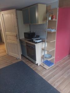 a small kitchen with a stove and a open door at 4 Zimmer Wohnung in Albstadt