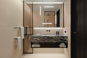 bagno con lavandino e specchio di Koenigshof, a Luxury Collection Hotel, Munich a Monaco