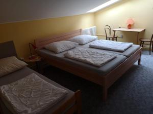 een slaapkamer met 2 bedden en een tafel en stoelen bij Apartmán U kostela in Železná Ruda