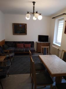 ein Wohnzimmer mit einem Sofa und einem Tisch in der Unterkunft Apartmán U kostela in Železná Ruda