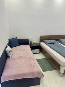 a bedroom with two beds and a night stand at SMART GuestHouse in Oradea