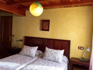 a bedroom with a bed with white sheets and a lamp at Apartamentos Rurales Casa Ron in Coaña +126 photos