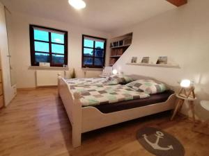 een slaapkamer met een bed en 2 ramen bij Ferienwohnung Fernblick in Osdorf