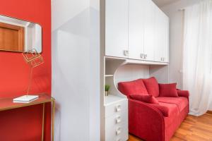 ミラノにあるCasa da Suite Arcoのリビングルーム(赤い椅子、白いキャビネット付)