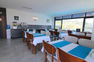 un restaurante con mesas y sillas azules y blancas en Ornella Butik Otel, en Edremit