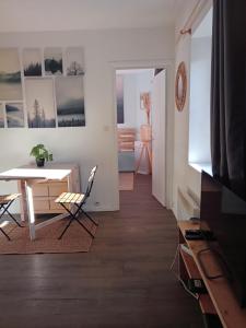 ein Wohnzimmer mit einem Tisch, einem Tisch und Stühlen in der Unterkunft Appartement calme, hyper centre. in Clermont-Ferrand