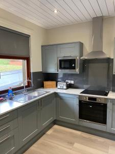 una cocina con armarios grises y fregadero en Welltrees Apartments 14 Dailly Road Maybole, en Maybole
