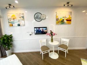 a white room with a table and chairs and a tv at T98 Westlake Apartment in Hanoi