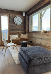 a bedroom with a couch and a clock on the wall at Paradis Perdu SKI IN & QUIET chalet 10 personnes in Les Collons