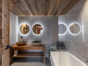 a bathroom with two sinks and a tub and mirrors at Le Cheval Blanc et Le Loup Blanc, jacuzzi, hammam, skis aux pieds in Méribel