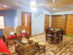 a living room with a table and chairs at Pine Paradise Homestay in Shimla