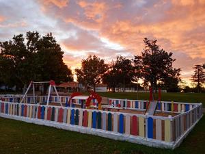 a playground in a park at sunset with aoc at Albergue Zaragoza Camping in Zaragoza