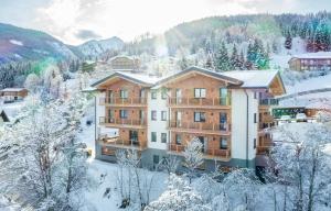 an apartment building in the snow with trees at Höflehner Premium Gumpen Lodge in Haus im Ennstal