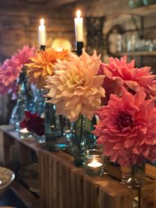 a bunch of flowers in vases on a table with candles at Torpgården in Torsby