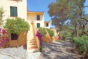 a house with purple flowers on the stairs at The Yellow Houses in Ayios Nikolaos Sithonia