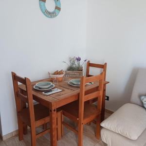 een houten tafel met twee stoelen en borden erop bij Casa Barbara in Costa de Antigua