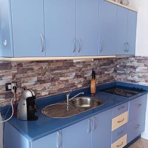 a kitchen with blue cabinets and a sink at Casa Barbara in Costa de Antigua