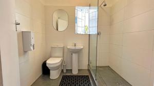 y baño con aseo, lavabo y espejo. en Long Street Backpackers, en Ciudad del Cabo