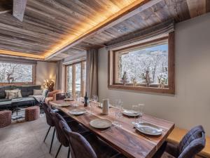 una sala da pranzo con un grande tavolo in legno e sedie di Le Cheval Blanc et Le Loup Blanc, jacuzzi, hammam, skis aux pieds a Méribel