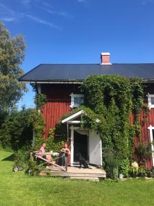two people and a cat sitting on the porch of a house at Torpgården in Torsby