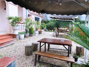 eine Terrasse mit einem Tisch, Bänken und Topfpflanzen in der Unterkunft Gia Bảo Homestay - Cao Bằng in Cao Bằng