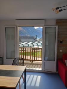 a living room with a red couch and a balcony at La Campana 107 in Bielle +23 photos
