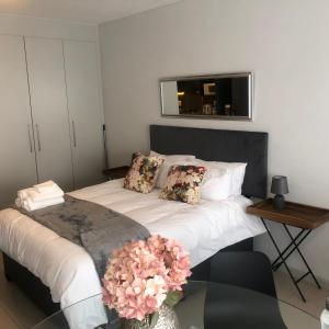 een slaapkamer met een bed met bloemen erop bij OAM The View Morningside in Johannesburg