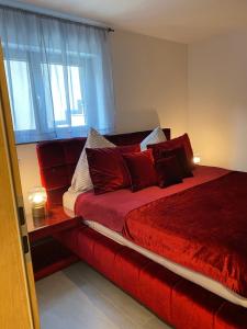 a bedroom with a red bed with a window at FeWo Souterrain TT-Bodensee in Tettnang